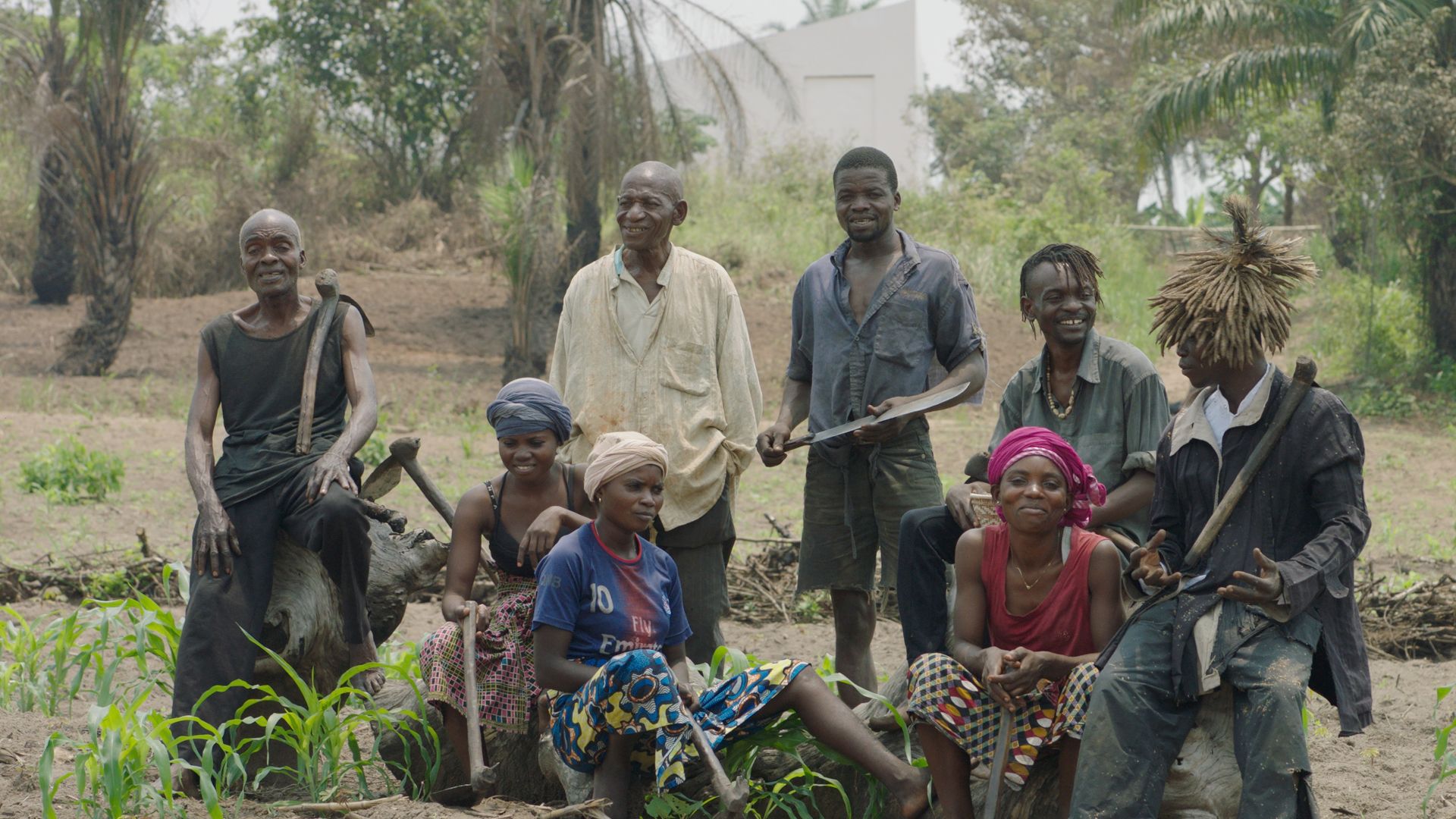 Leden van de kunstenaarsvereniging van Congolese plantagearbeiders (CAPTC) in Lusanga, Congo. van links naar rechts: Olele Mulela Mabamba, Irène Kanga, Huguette Kilembi, Jérémie Mabiala, Jean Kawata, Mbuku Kimpala, Ced'art Tamasala en Matthieu Kasiama. Op de achtergrond de tentoonstellingsruimte White Cube