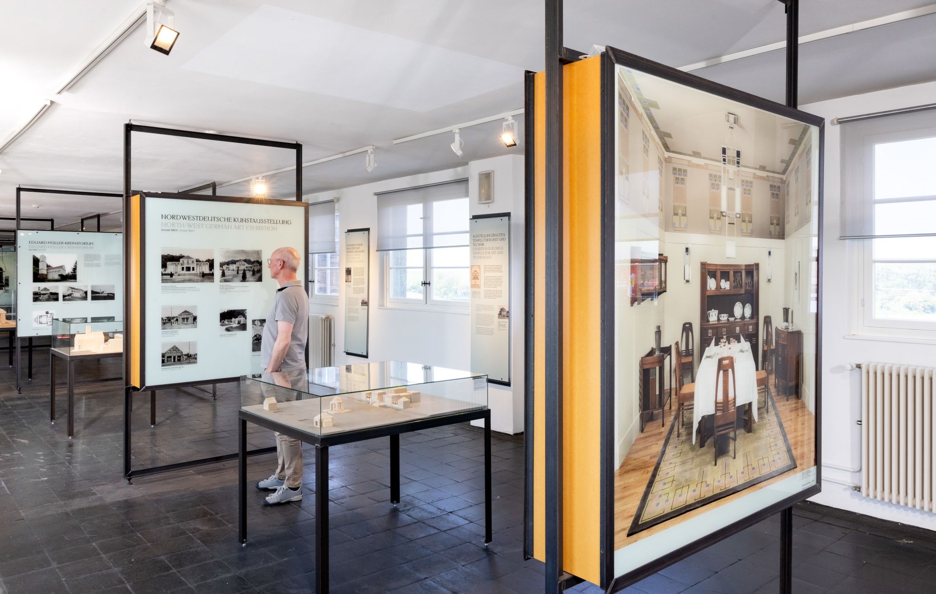 Een museumgast bekijkt vitrines in de permanente tentoonstelling in het Peter Behrens Gebouw