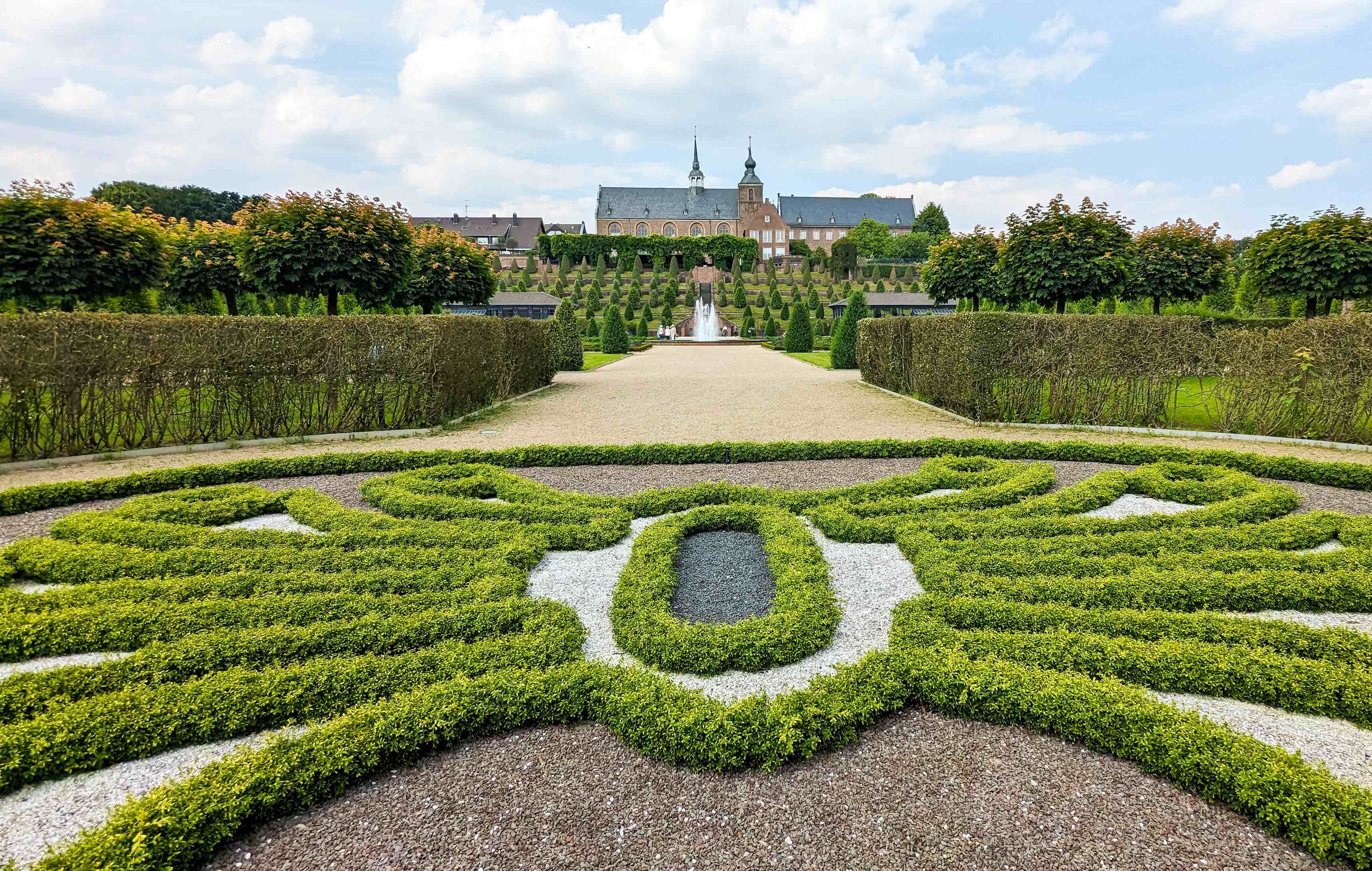 Stijgende terrasvormige tuin met klooster op de achtergrond