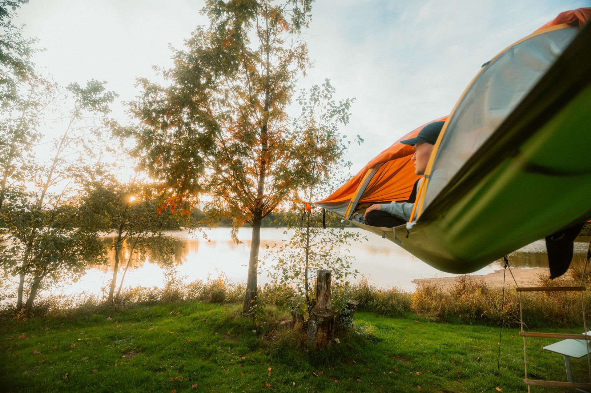 Person im Schwebezelt blickt auf See des Campingplatzes Dingdener Heide