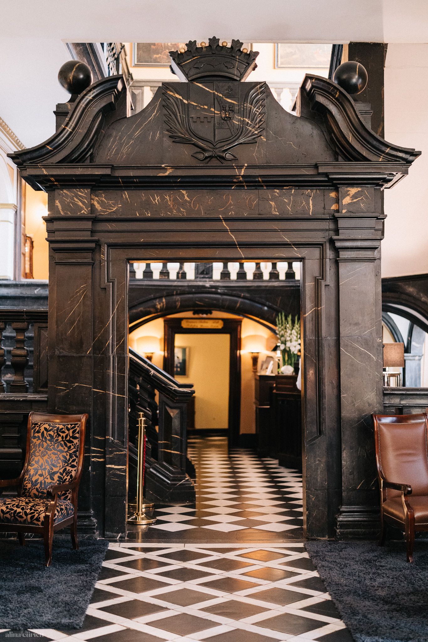 Binnenin het hoofdgebouw trekken stucplafonds, marmeren deuren en elegante houten trappen de aandacht.