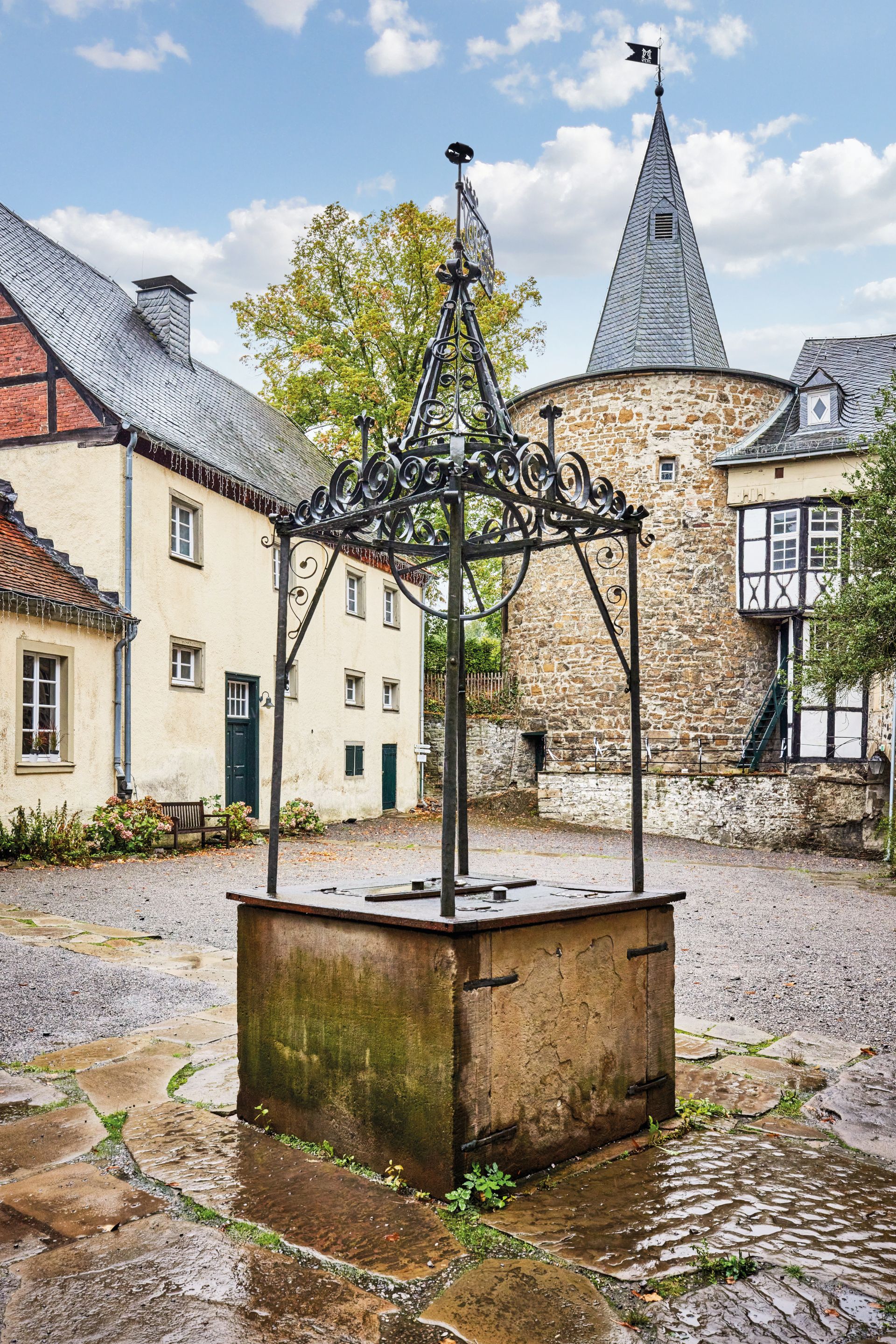Op de binnenplaats van kasteel Hohenlimburg staat een fontein met een smeedijzeren bovenkant uit 1749