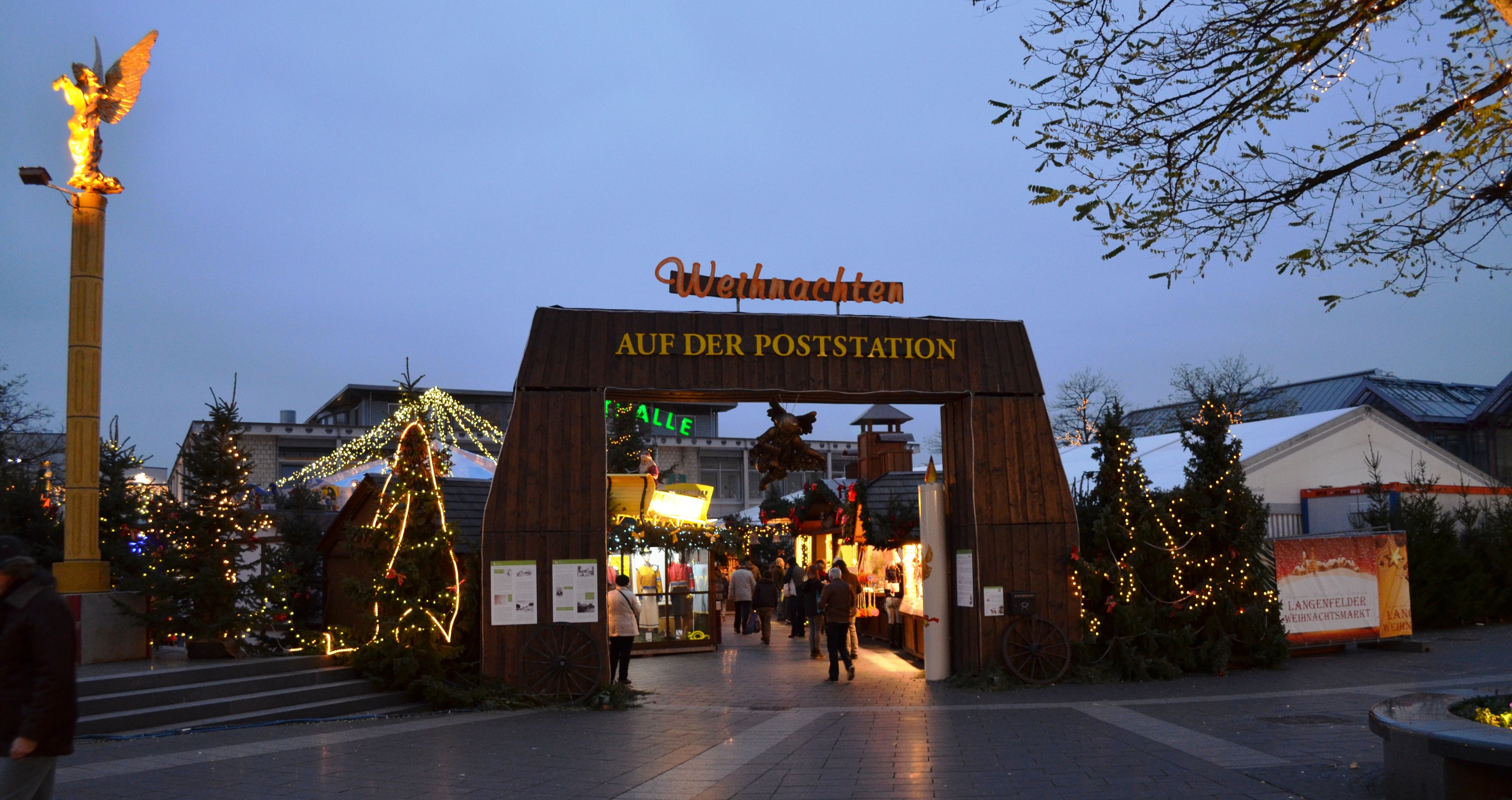Ingang tot het Langenfelder kerstdorp, versierd met lichtjes en kerstversieringen.