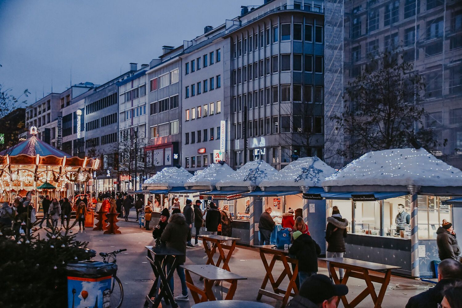 In de schemering komen de lichtjes van de kraampjes en de verlichte draaimolen op de Schadow-Markt in Düsseldorf pas echt tot hun recht.