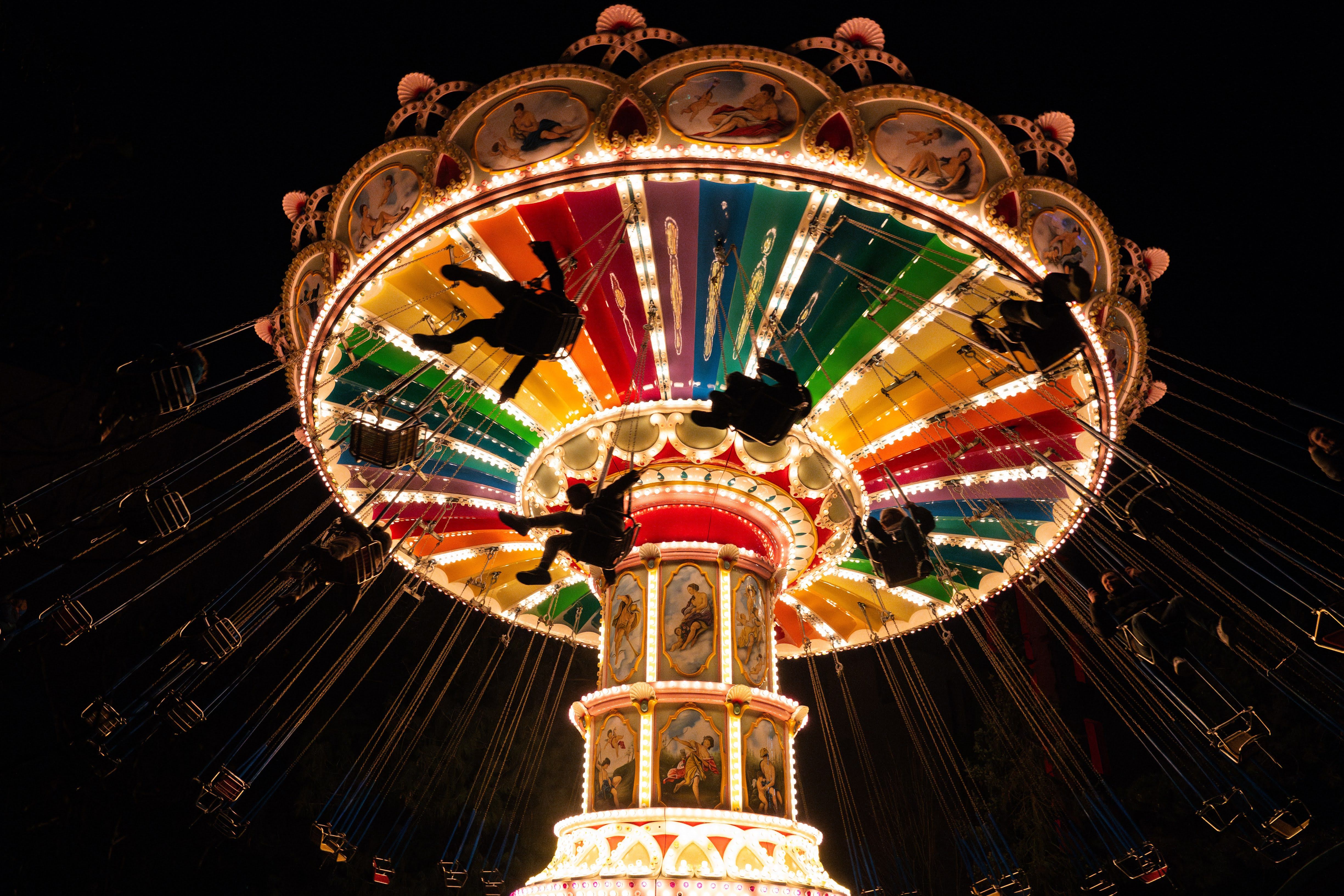 Een kleurrijk verlichte kettingcarrousel draait 's nachts in Wunderland Kalkar.