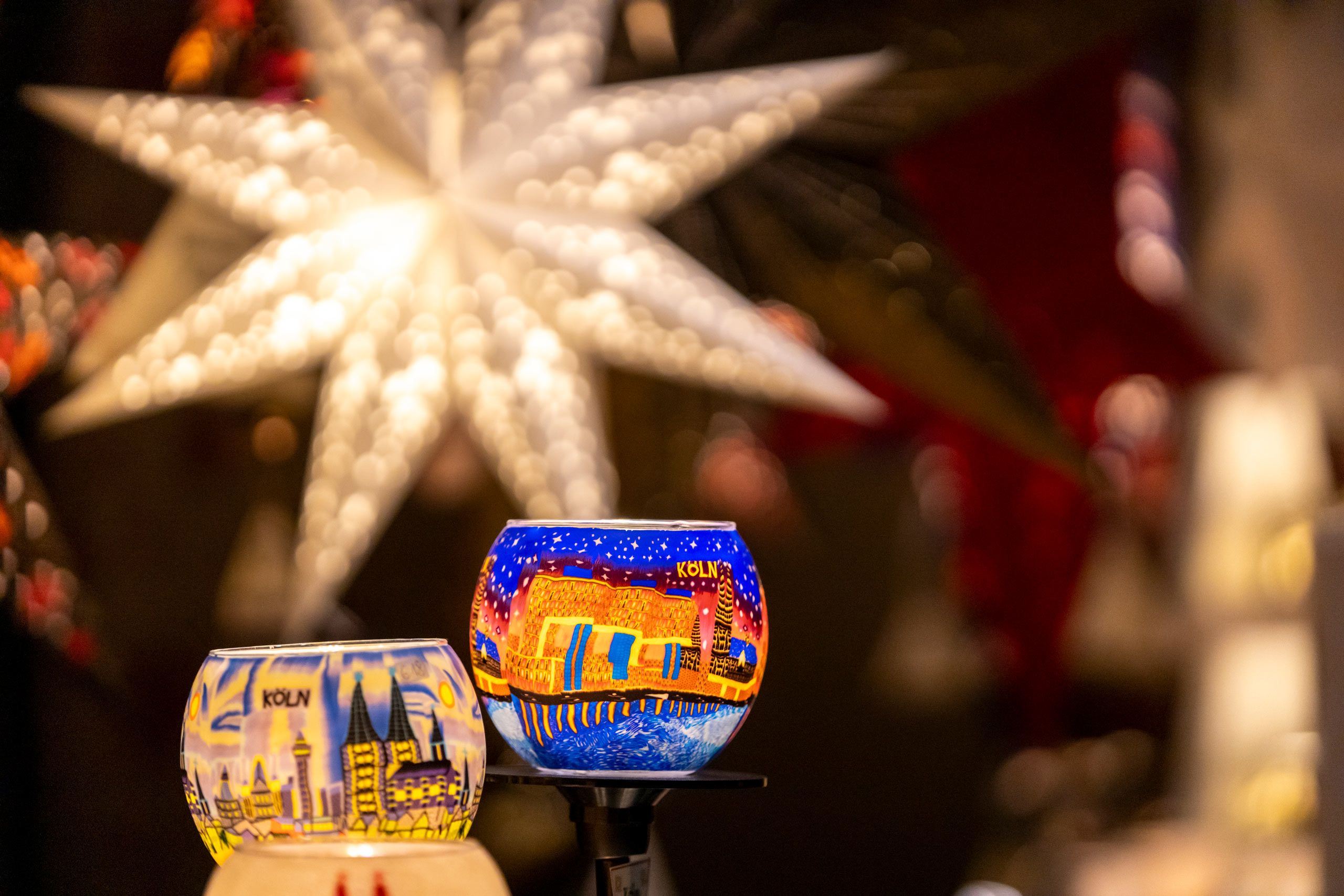 Kleurrijke kandelaars met Keulse motieven en op de achtergrond een grote, stralende ster zorgen voor een feestelijke sfeer op de Markt der Engel.