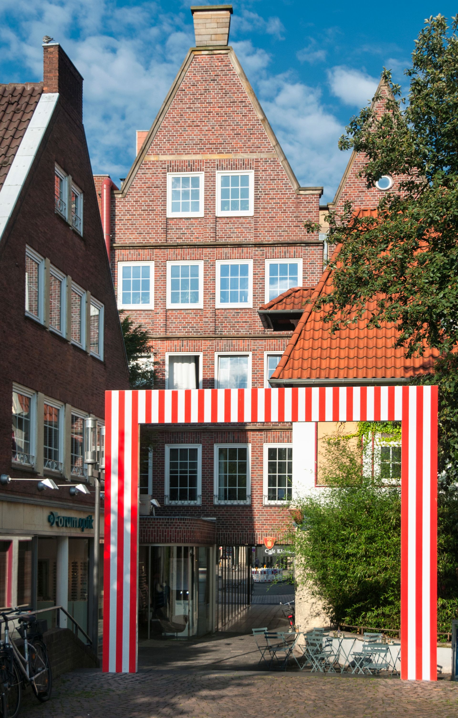 De rood-witte poort van de Franse kunstenaar Daniel Buren markeert de historische overgang van de vrijheid van de kathedraal naar de stad. De bijdrage aan de beeldhouwprojecten van 1987 bestond destijds uit vier poorten