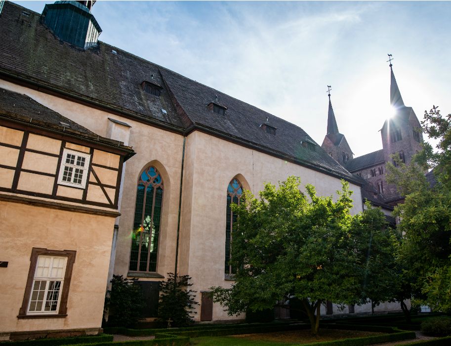 Buitenaanzicht van de voormalige kloosterkerk met het westwerk en de kerktorens op de achtergrond