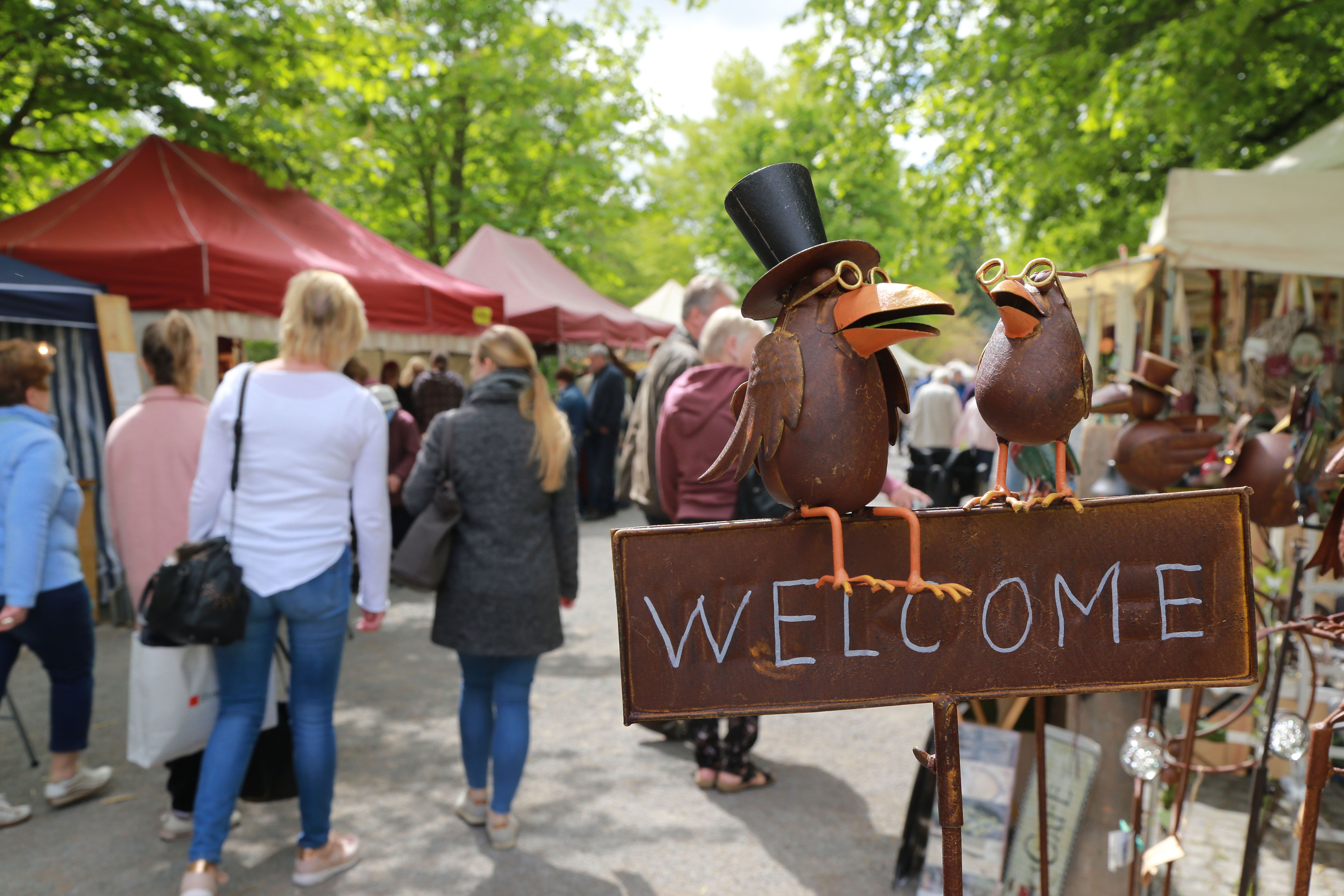 Metalen vogels met hoge hoeden en brillen heten je welkom op de ambachts- en boerenmarkt in Bad Sassendorf.