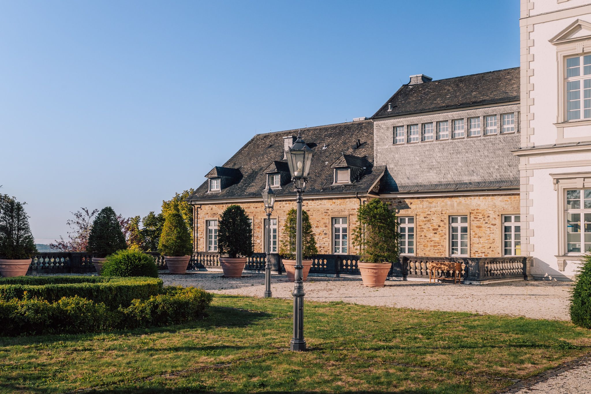 Buitenaanzicht van het Grandhotel Schloss Bensberg met uitzicht op de tuin in de herfst