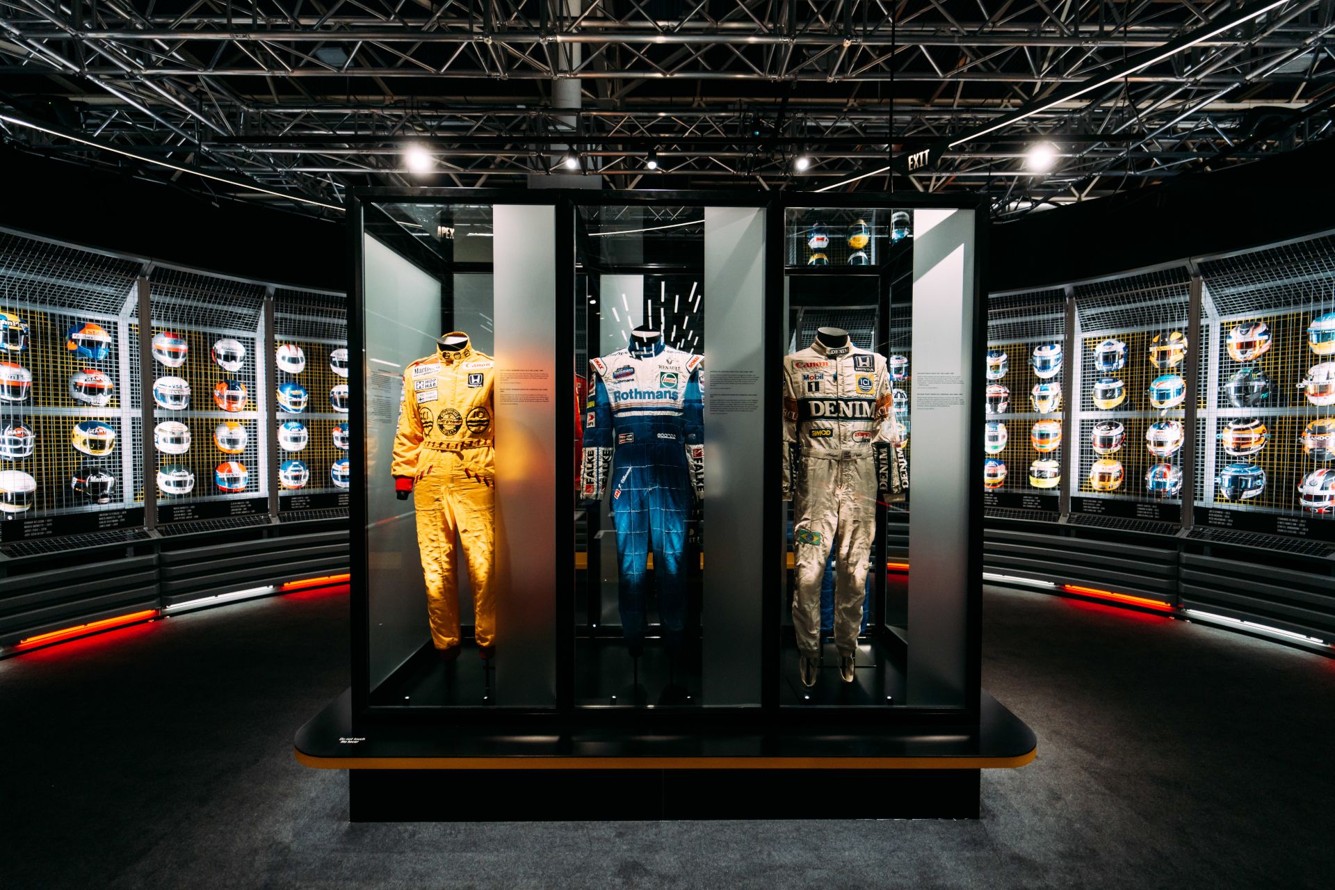 In de themaruimte "Drivers & Duels" komen gasten een tentoonstellingswand tegen met bijna 100 helmen en een aantal pakken.