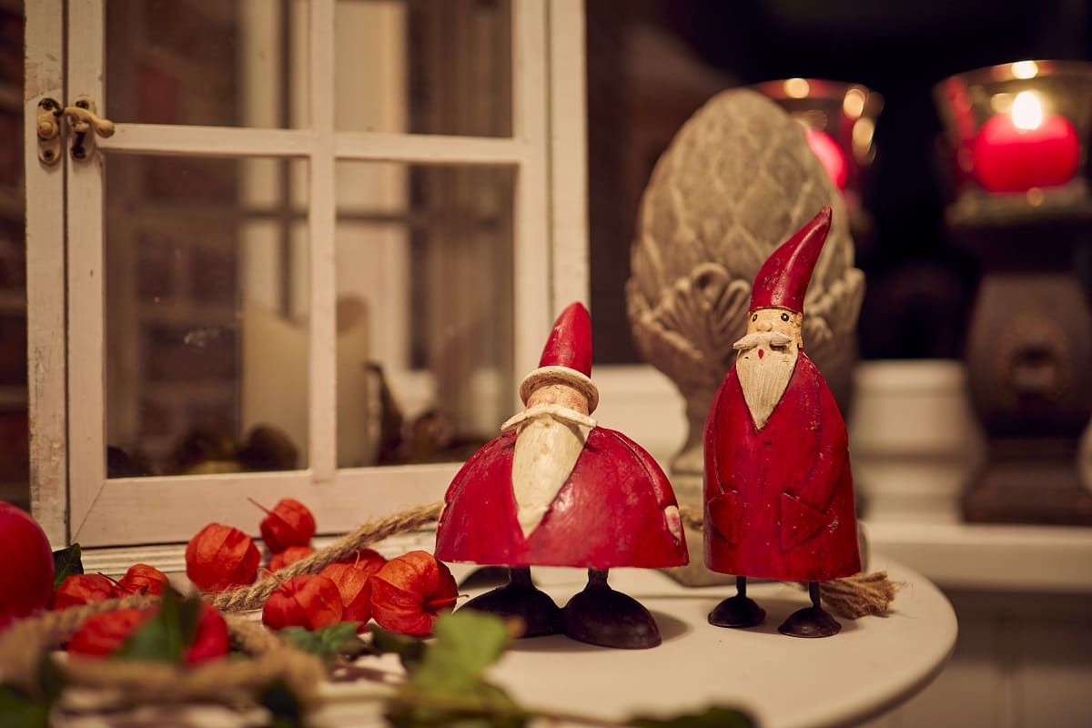 Twee rode houten kerstmannen staan op een tafel.