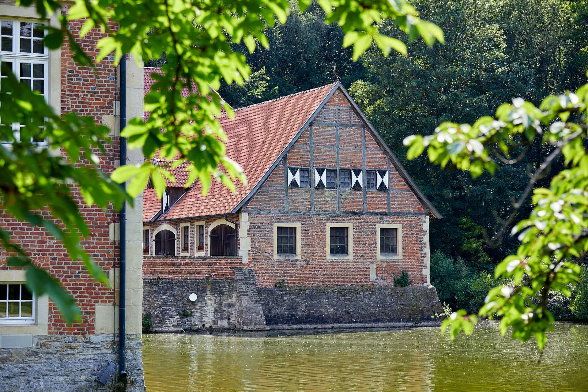 Uitzicht door de bomen naar kasteel Hülshoff in Münsterland