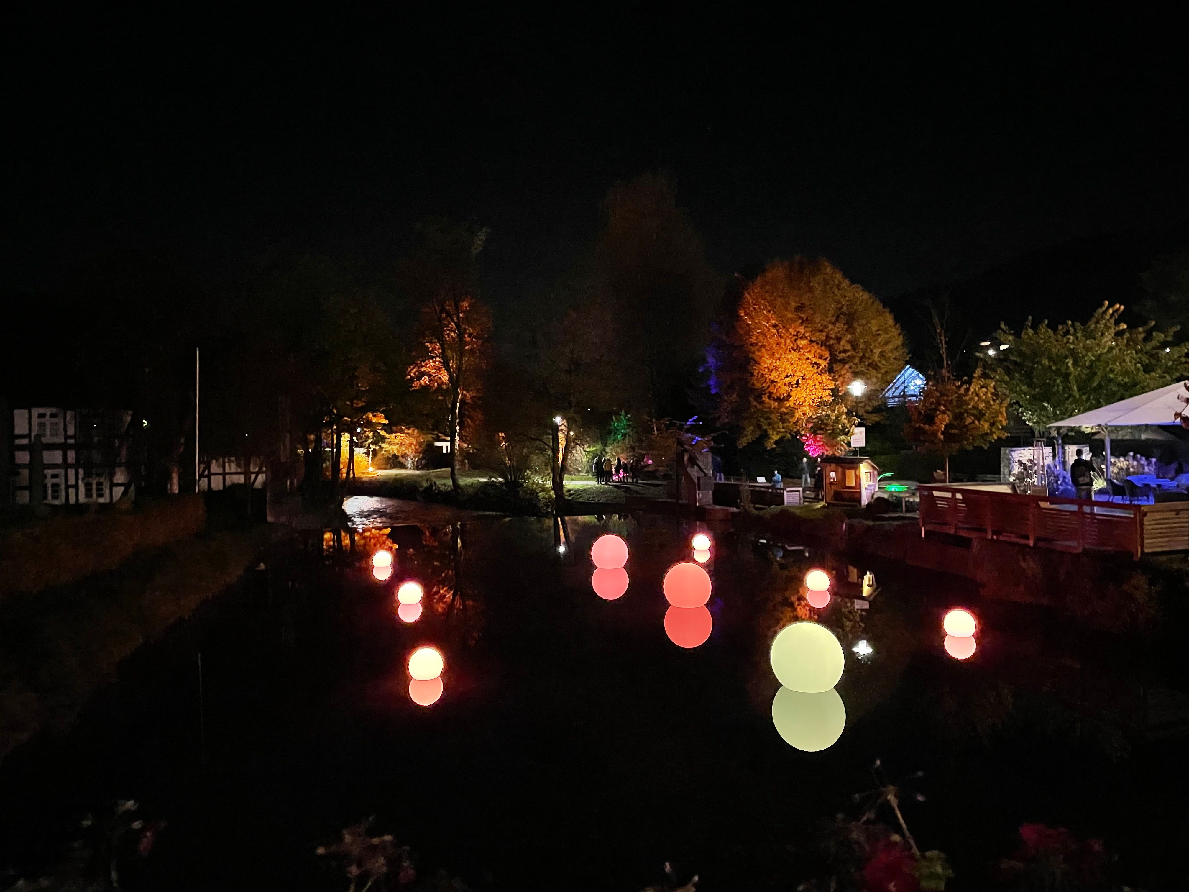 Gloeiende bollen drijven 's nachts op een rivier in Lennestadt.