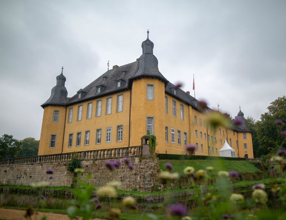 Kasteel Dyck in Jüchen presenteert zich met bloemen op de voorgrond.